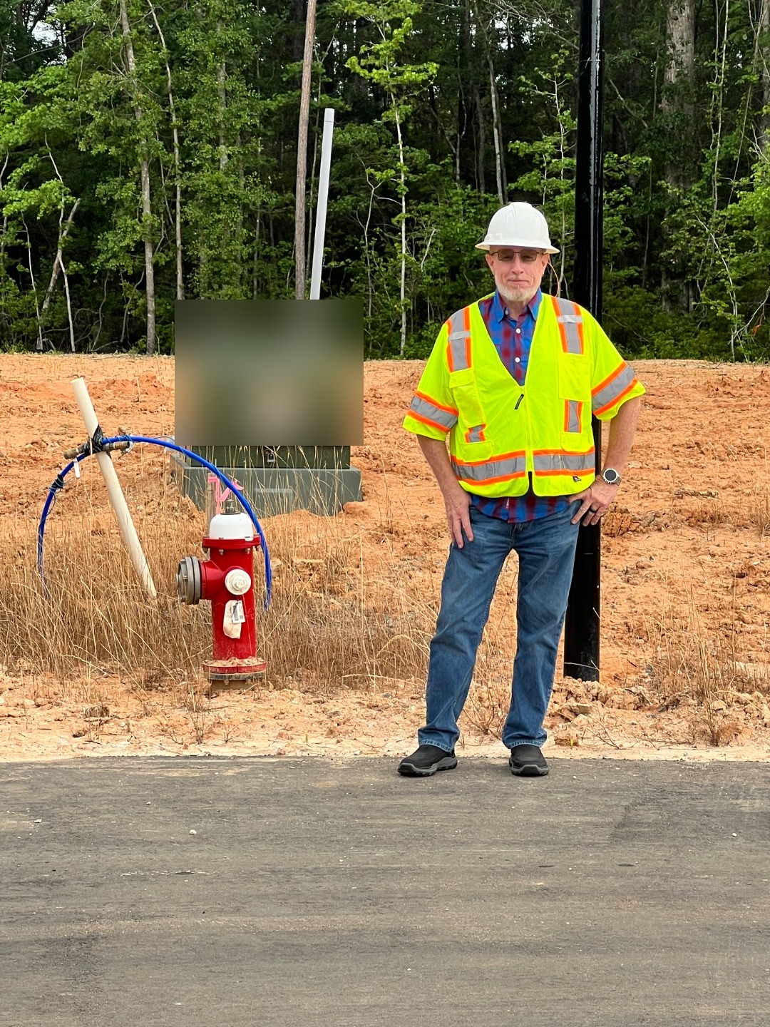 David Self, founder of BlueStake Solutions, standing on an active subdivision job site in hard hat and hi-vis vest